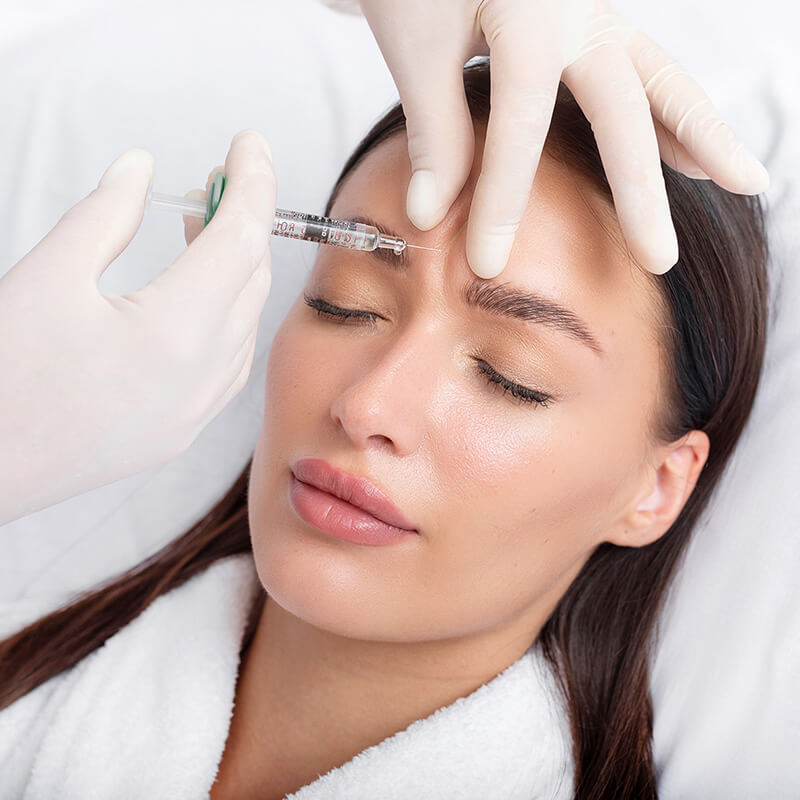 Woman getting an injection on her forehead