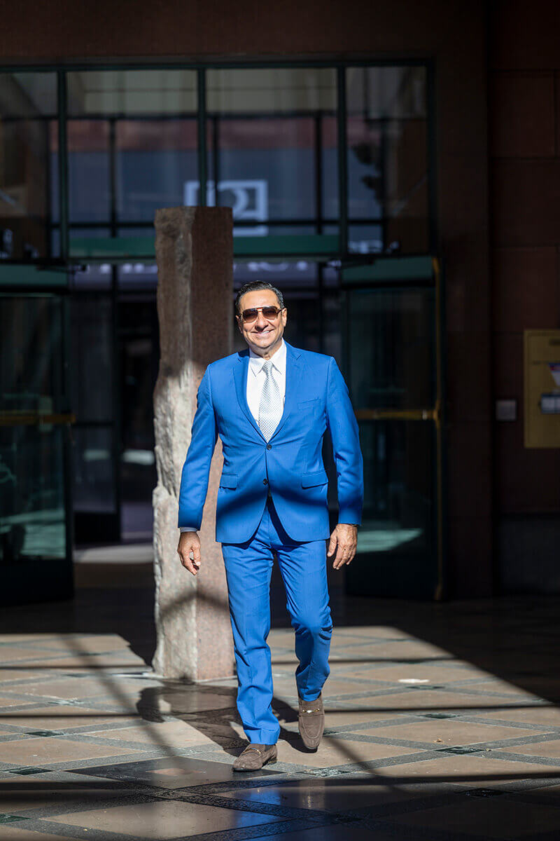 Dr. Kadz in a blue suit walking