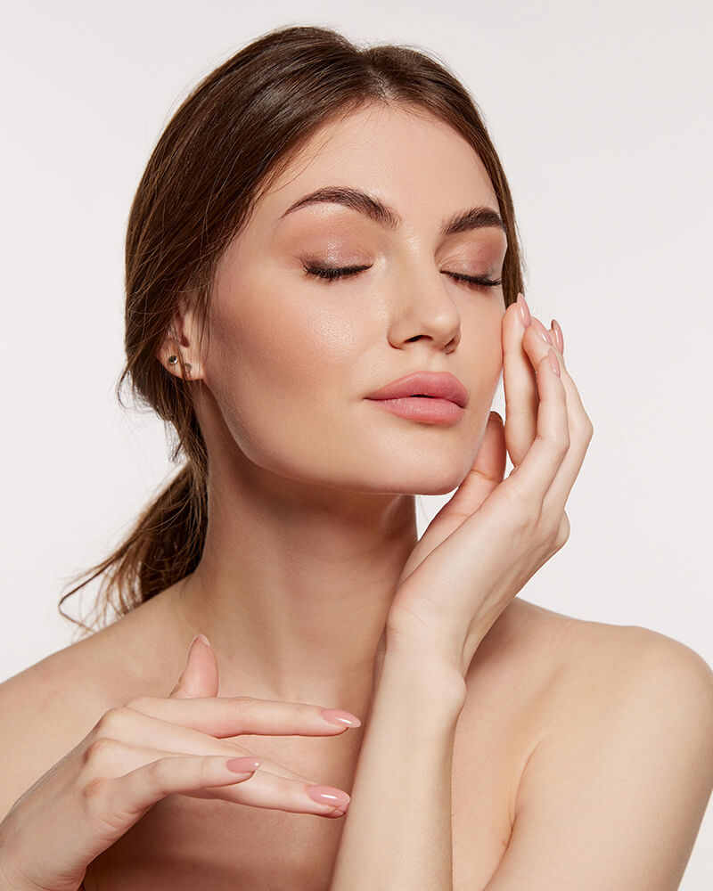 Woman with her eyes closed touching her face