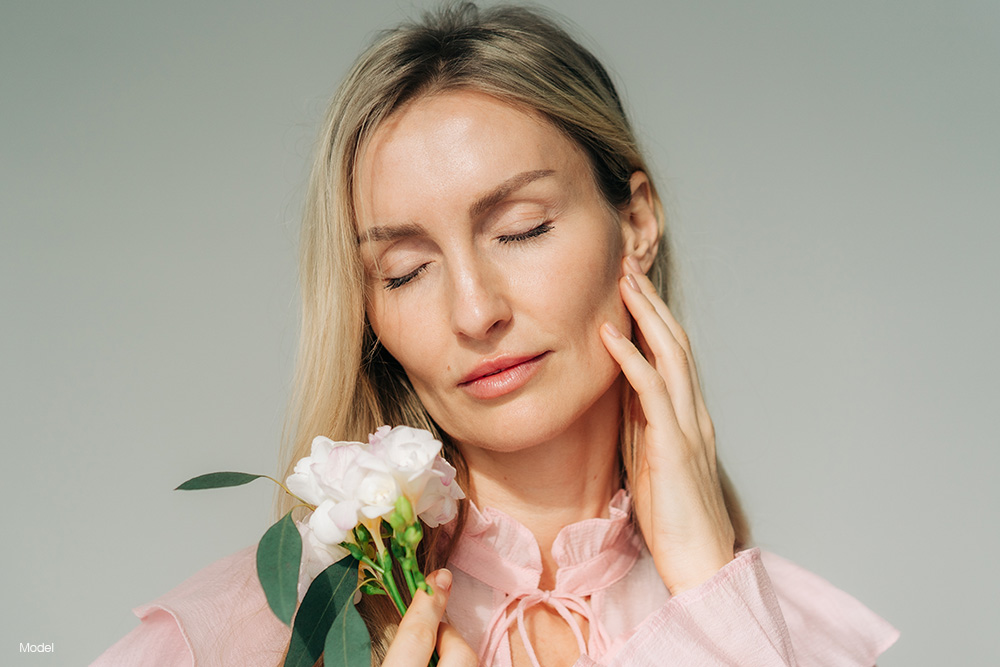 mature woman in a pink shirt holding flowers
